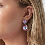 Close-up of a woman wearing colorful earrings with a light background