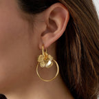 Gold hoop earring worn by a person with brown hair.