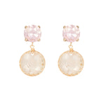 Pair of earrings with pink and beige stones on a white background