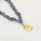 Blue braided bracelet with a gold pendant on a light gray background